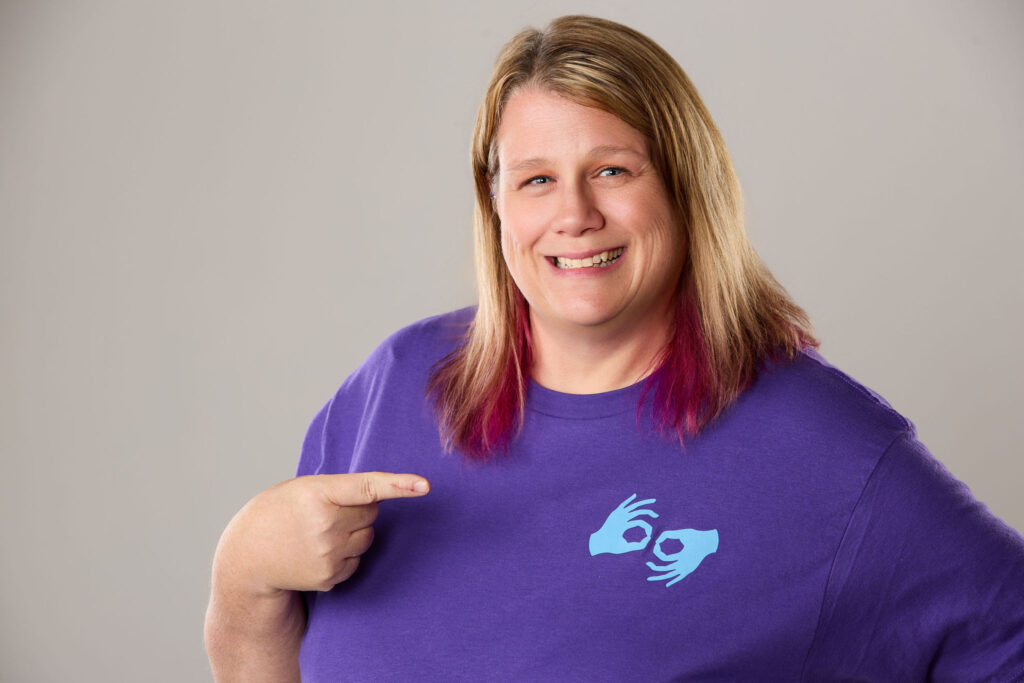 Lori pointing to the interpretation logo